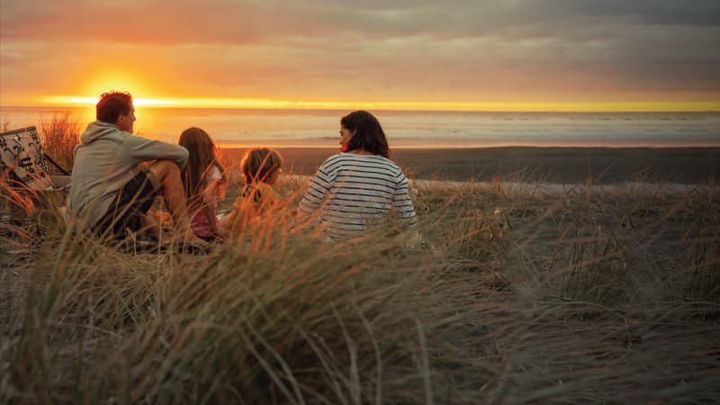 Family overlooking beach at sunset